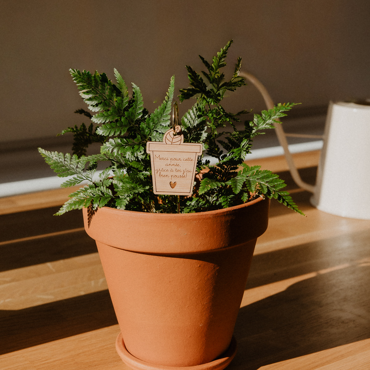 Les petites hirondelles 2026 Pic Botanique avec tige en métal et élément en bois de bouleau en forme de pot de fleur et écriture "merci pour cette année" dans une plante