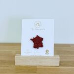 Pin's feutrine pailletée rouge en forme de carte de la France