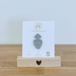 Pin's feutrine pailletée argenté en forme de symbole sacré cœur