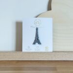 Pin's feutrine pailletée argenté en forme de tour Eiffel