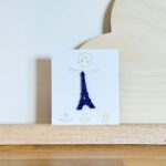 Pin's feutrine pailletée bleu en forme de tour Eiffel