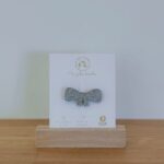 Broche paillette en forme de nœud et de couleur argent